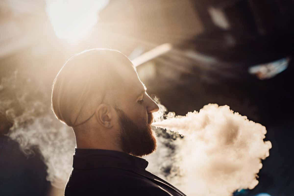 K4EW53 bearded man in a suit in the city vaping