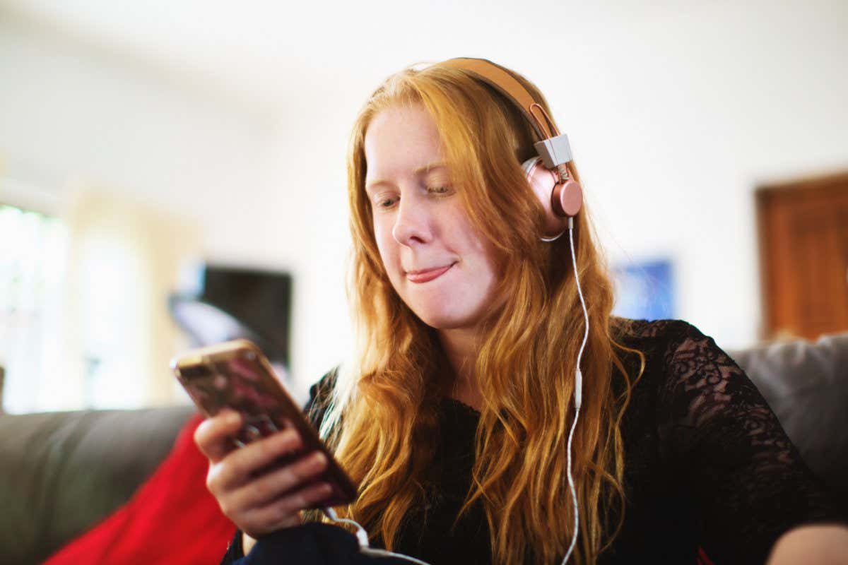 Young woman with a striking appearance enjoys listening to music on her headphones.
