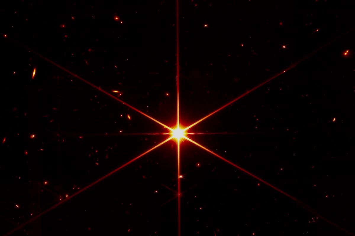 While the purpose of this image was to focus on the bright star at the center for alignment evaluation, Webb's optics and NIRCam are so sensitive that the galaxies and stars seen in the background show up. At this stage of Webb?s mirror alignment, known as ?fine phasing,? each of the primary mirror segments have been adjusted to produce one unified image of the same star using only the NIRCam instrument. This image of the star, which is called 2MASS J17554042+6551277, uses a red filter to optimize visual contrast.