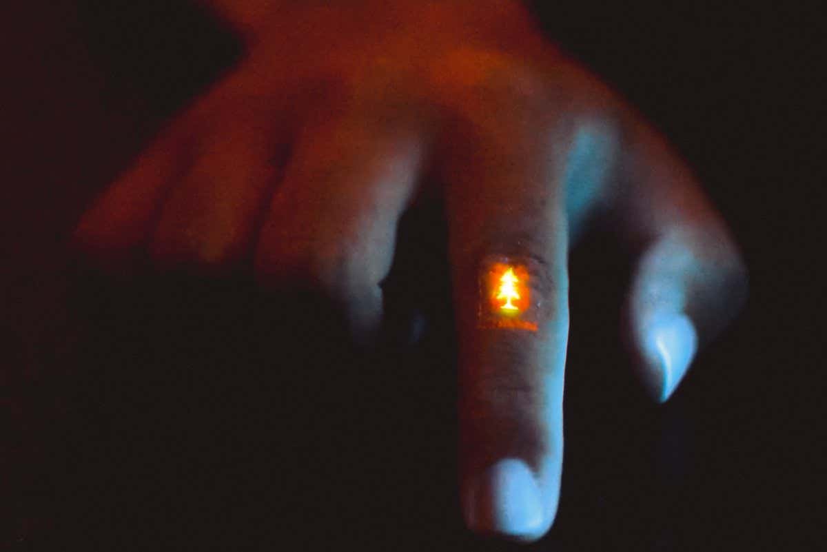 Zhitao Zhang wears the flexible light-emitting film, featuring a Stanford logo.