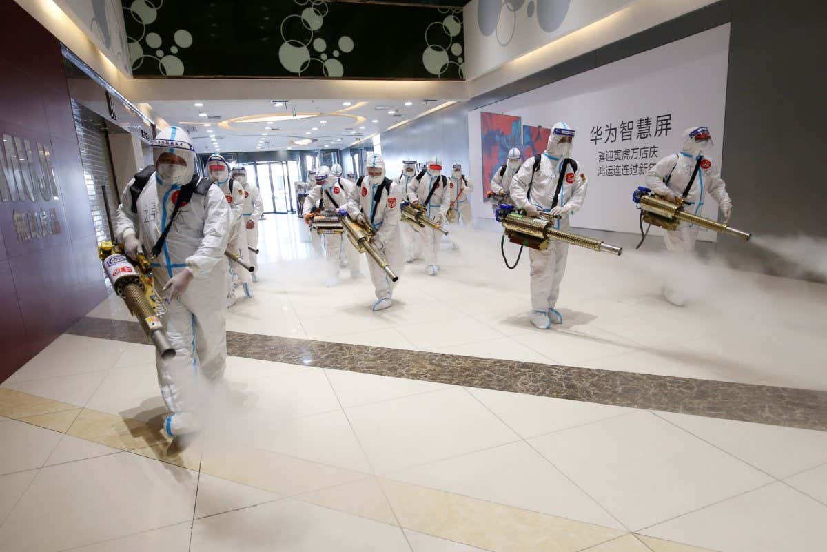 WEIFANG, CHINA - MARCH 24: Workers wearing personal protective equipment (PPE) conduct disinfection work at a shopping mall on March 24, 2022 in Weifang, Shandong Province of China. (Photo by Zhang Chi/VCG via Getty Images)