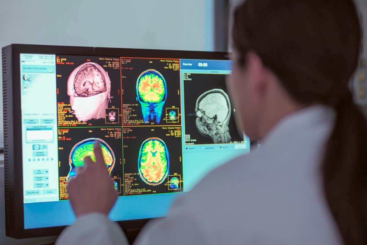 UK, North Yorkshire, Female doctor looking at MRI scanner monitor