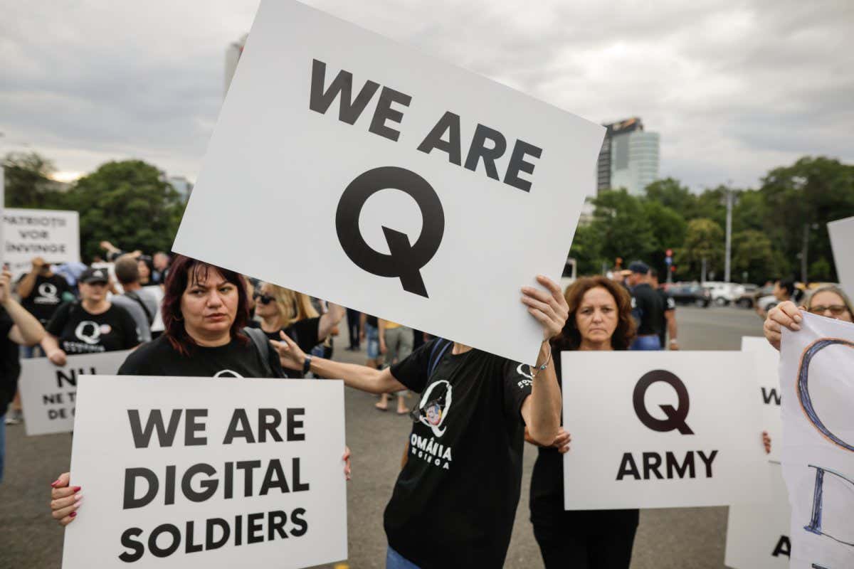 Bucharest, Romania - August 10, 2020: People display Qanon messages on cardboards during a political rally.; Shutterstock ID 1796596942; purchase_order: NS 09 April 2022 issue; job: Photo; client: NS; other:
