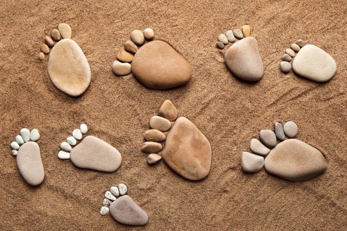 fun trace bare feet walking, made of pebble stones on the top view surface beach sand background; Shutterstock ID 115546069; purchase_order: -; job: -; client: -; other: -