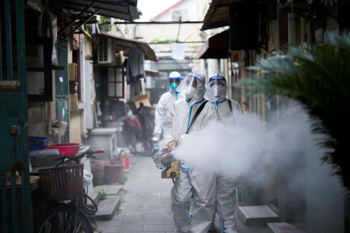 People disinfect a residential area under lockdown in Shanghai, China, on 15 April