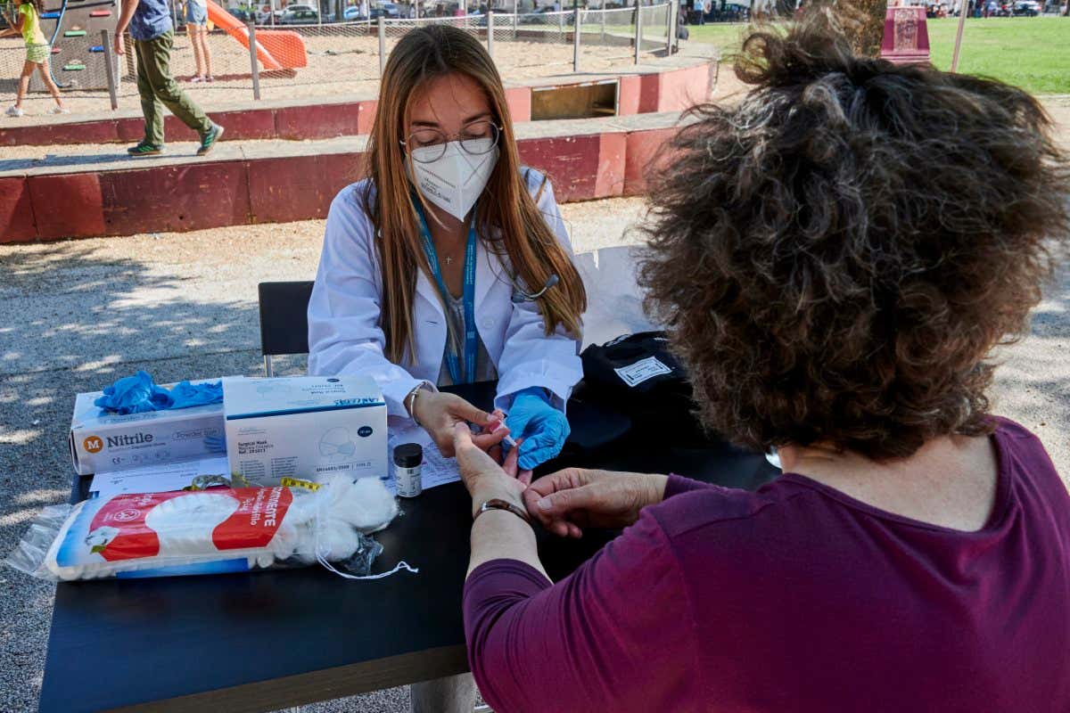 LISBON, PORTUGAL - MAY 29: A mask-clad Nova Medical School final-year student gives a woman a blood glucose test to check possible diabetes at a screening post in Alameda Dom Afonso Henriques during the COVID-19 Coronavirus pandemic on May 29, 2021 in Lisbon, Portugal. Nova Medical School final-year students perform free cardiovascular screening, hypertension, diabetes and obesity check-ups to passers-by in a joint project with Lisbon's Areeiro Parish (Photo by Horacio Villalobos#Corbis/Corbis via Getty Images)