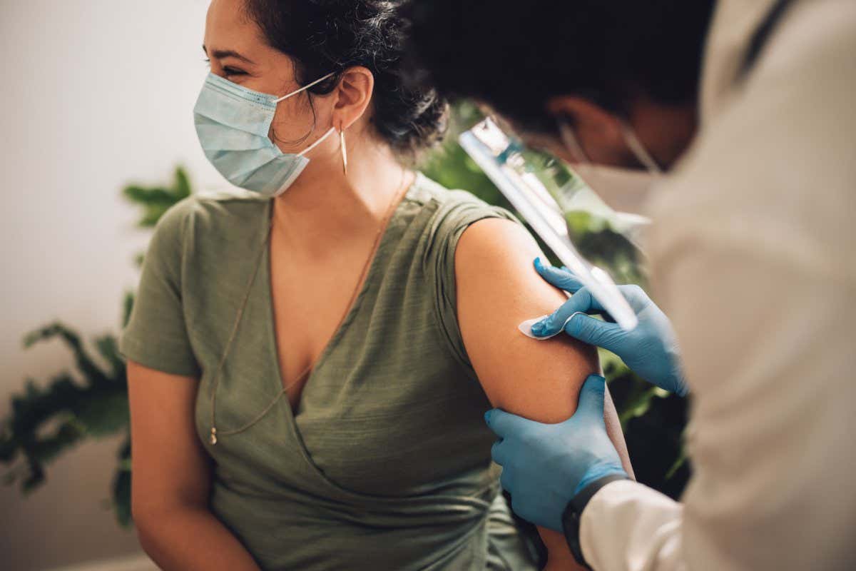 Doctor prepping a womans arm with alcohol swop. Female getting her arm disinfected for her covid vaccine.; Shutterstock ID 1976002664; purchase_order: -; job: -; client: -; other: -