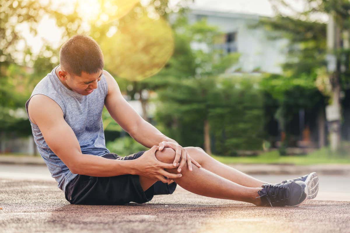 Runner man with sports running knee injury. Hands holding knee with painful ; Shutterstock ID 1453204064; purchase_order: -; job: -; client: -; other: -