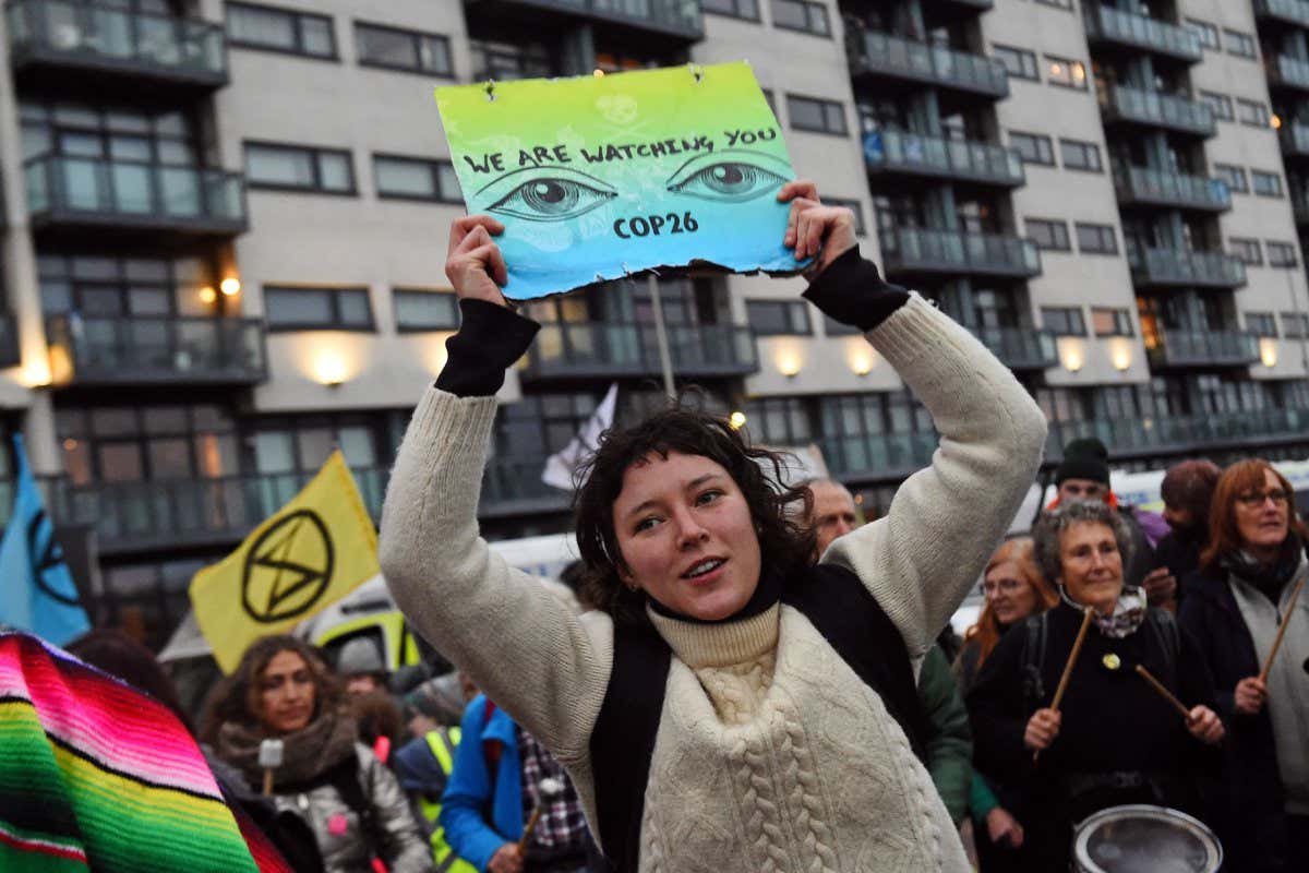 TOPSHOT - Activists from the climate change group Extinction Rebellion (XR) take part in a protest in Glasgow on November 8, 2021, during the COP26 UN Climate Change Conference. - The COP26 climate talks resuming Monday have so far unfolded on parallel planes, with high-level announcements stage-managed by host country Britain during week one riding roughshod over a laborious UN process built on consensus among nearly 200 countries. (Photo by ANDY BUCHANAN / AFP) (Photo by ANDY BUCHANAN/AFP via Getty Images)