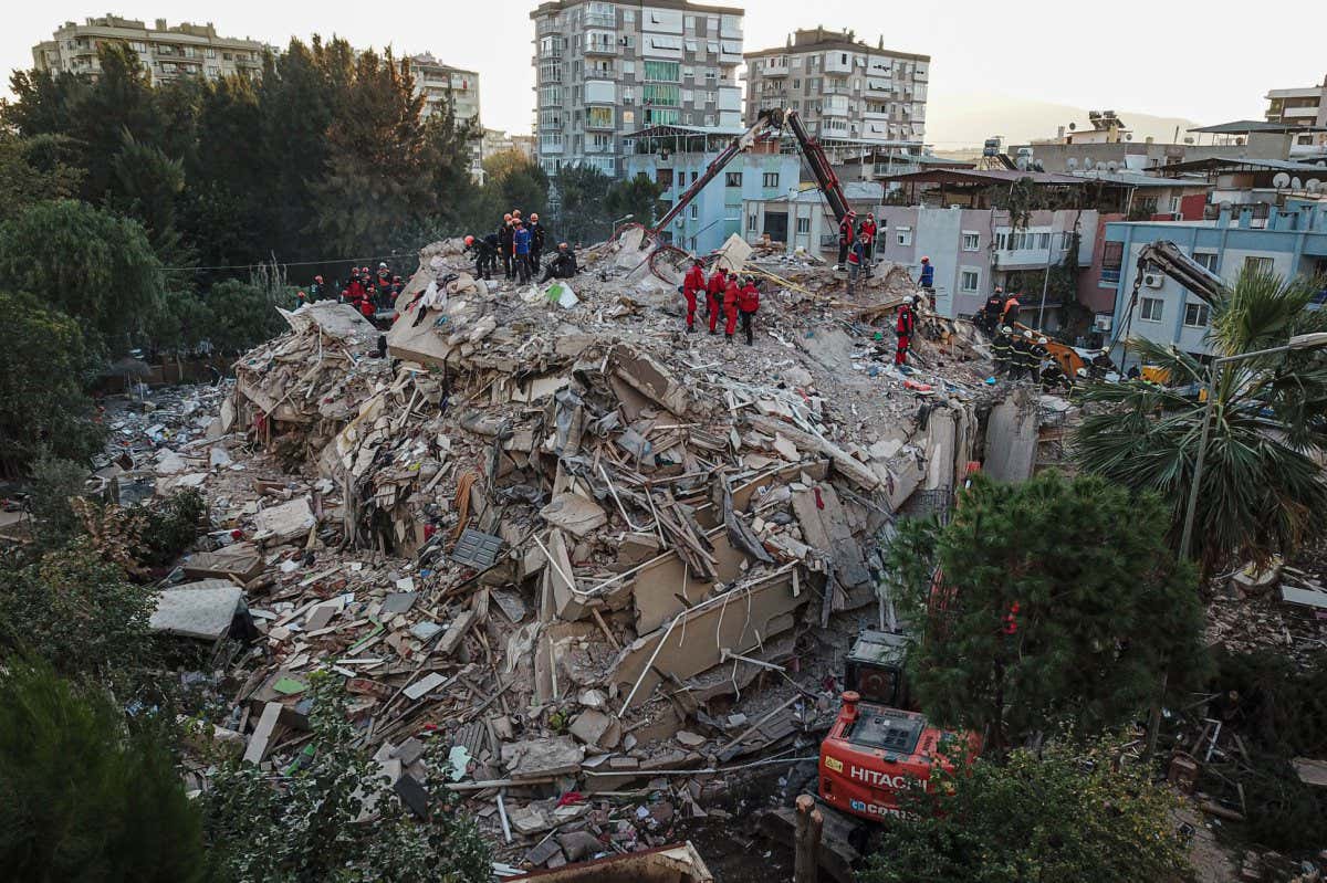 An aerial view taken on October 31, 2020, in Izmir shows Rescue workers searching for survivors in a collapsed building after a powerful earthquake struck Turkey's western coast and parts of Greece. - A powerful earthquake hit Turkey and Greece on October 30, killing at least 26 people, levelling buildings and creating a sea surge that flooded streets near the Turkish resort city of Izmir. (Photo by Ozan KOSE / AFP) (Photo by OZAN KOSE/AFP via Getty Images)
