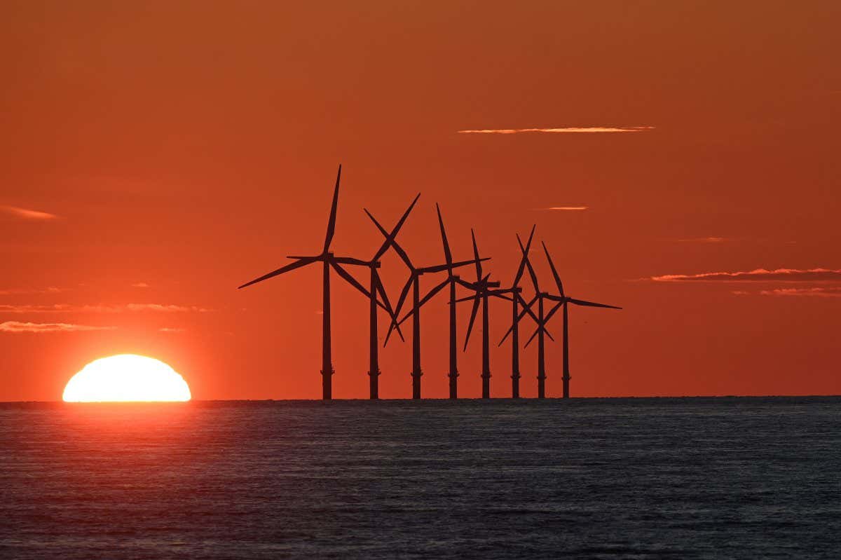 TOPSHOT - The sun sets behind the Burbo Bank Offshore Wind Farm in Liverpool Bay in the Irish Sea in north west England on May 26, 2021. (Photo by Paul ELLIS / AFP) (Photo by PAUL ELLIS/AFP via Getty Images)