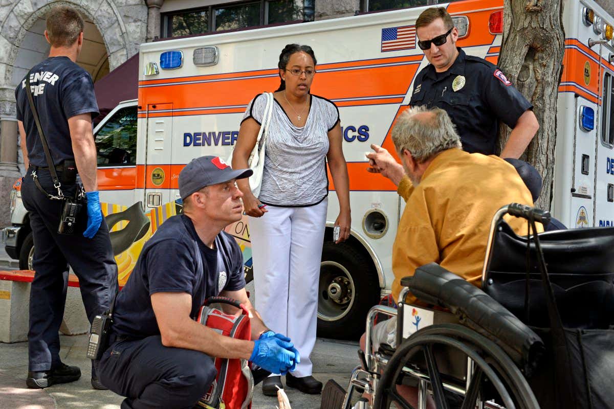 DENVER, CO. - JUNE 16: Edna Abraham Gezahegne is scolded by a man she found slumped over his wheelchair on the 16th Street Mall in Denver, CO, June 16, 2014. The man was angry at Edna for calling 911. She was sure the man needed medical attention and suspected he might have some mental health issues, 