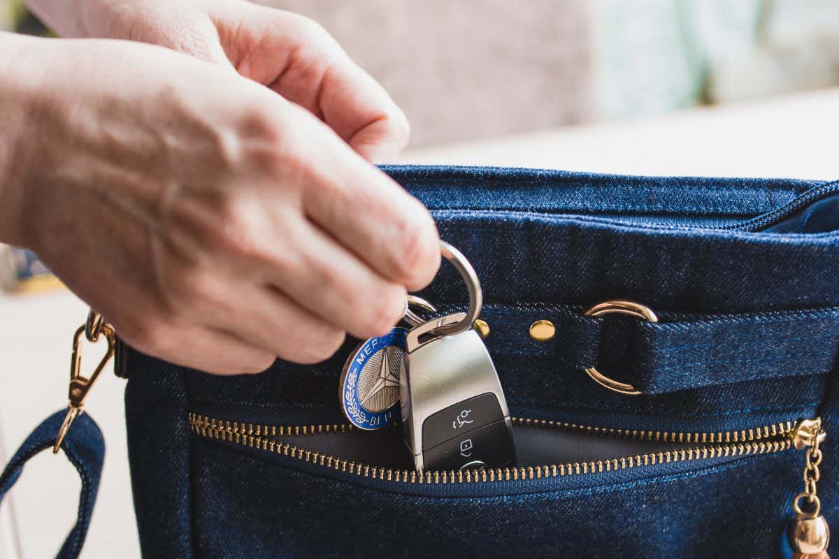 Minsk, Belarus - May 14, 2021: Woman puts a car key in the pocket of a denim bag - do not forget to take important things with you; Shutterstock ID 2022020750; purchase_order: -; job: -; client: -; other: -