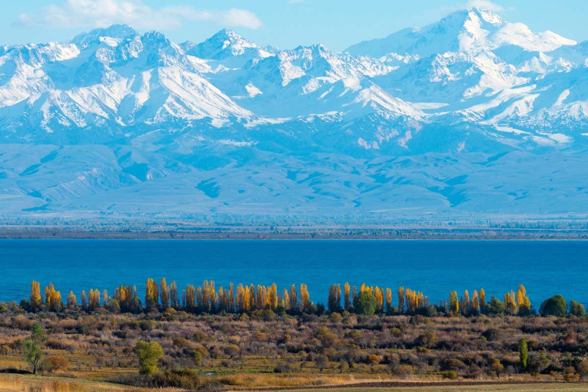 Issyk-Kul Lake (second biggest mountain lake in the world) in Kyrgyzstan in an autumn sunny day. Touristic area of this Central Asia country which has mountains in 80% of its territory. Snow visible.; Shutterstock ID 1551303815; purchase_order: -; job: -; client: -; other: -