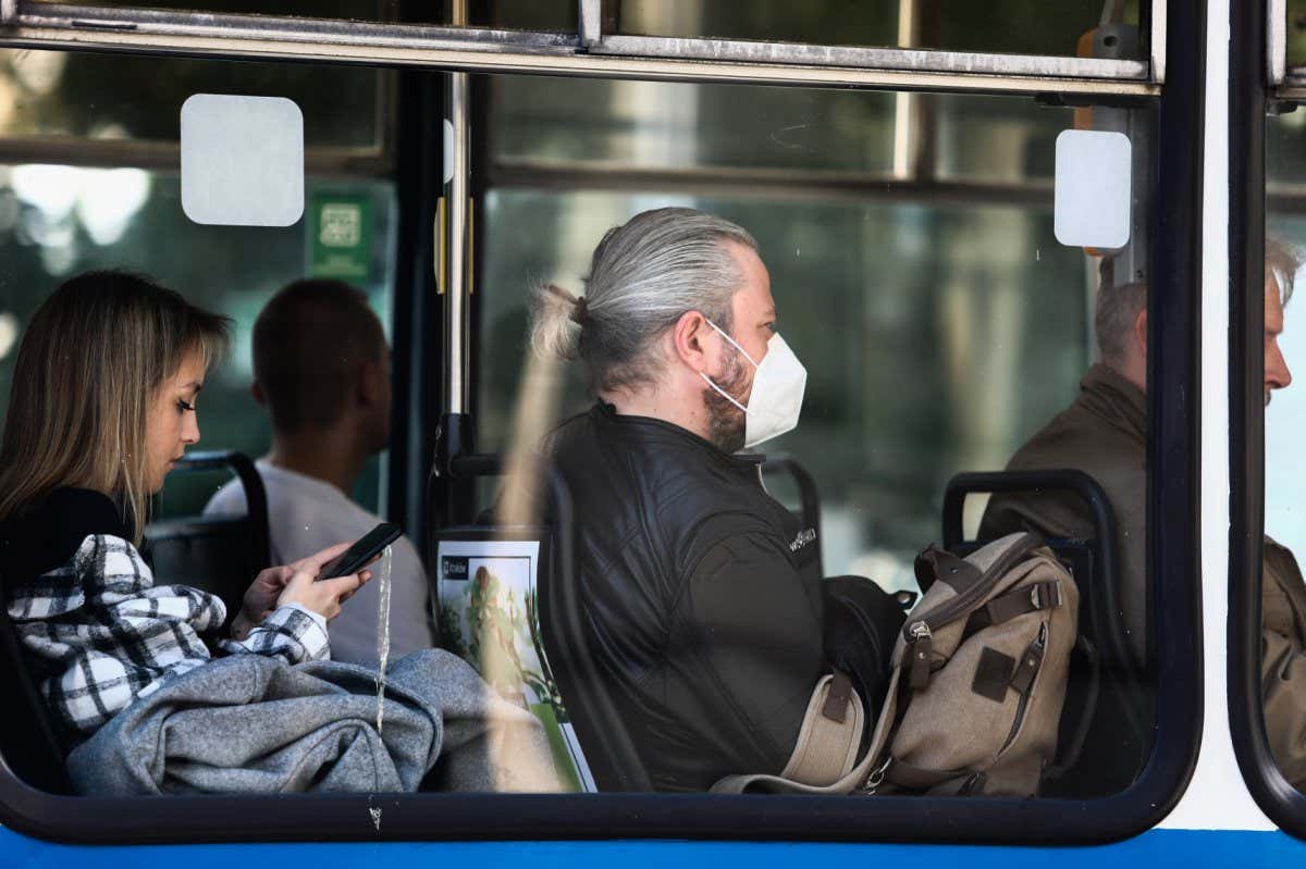 A person wearing a mask sits on a tram in Krakow, Poland, in May