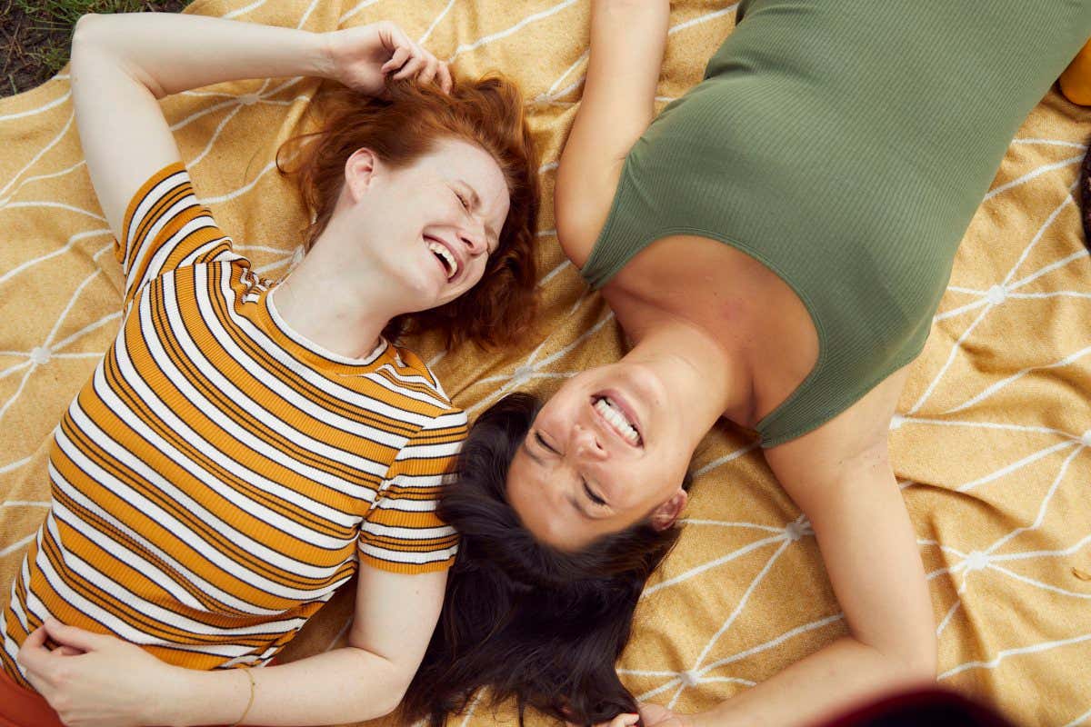 Two young women take a break on a picnic blanket