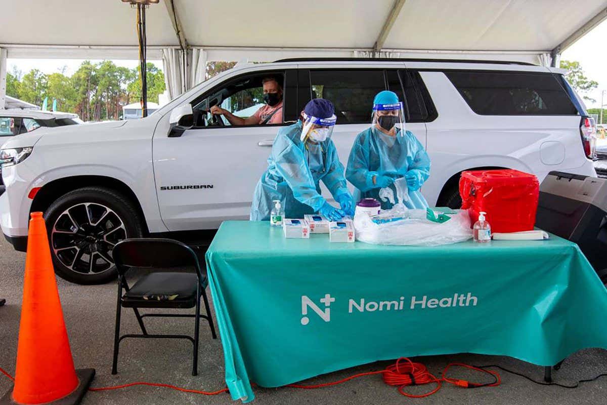 A person waits at a drive-in covid-19 PCR test site in Miami, Florida, in May