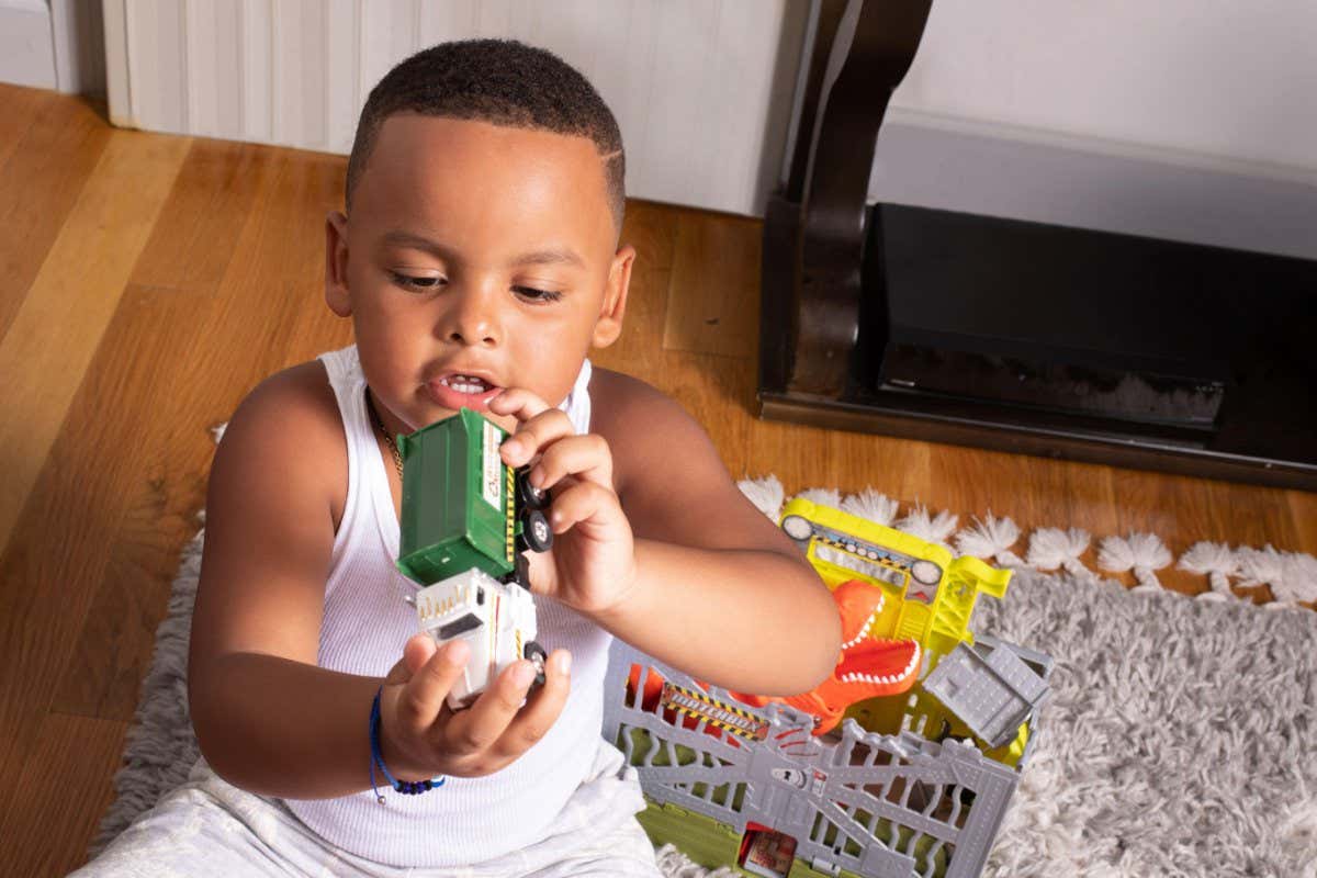 2H3WMC5 Preschool child at home age 4 or 5, playing with toy talking, talking