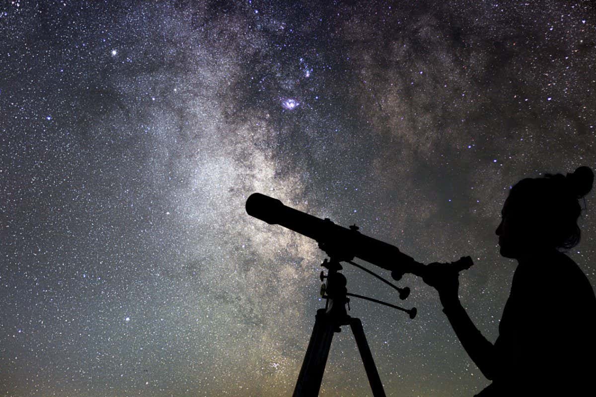 H3C989 Woman and night sky. Watching the stars Woman with telescope.