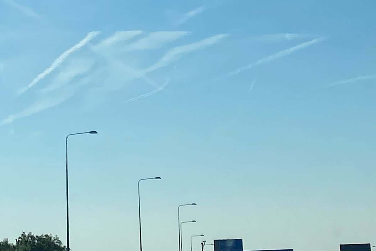This photograph is of the sky over north London on Wednesday 15th June at 8:13 am. The picture Is cropped to centre the image. The effect was not due to camera or glass of vehicle photo was taken from and looked identical to naked eye. What can have caused the contrails to end so evenly? No aircraft were immediately apparent, it did turn out to be a remarkable hot day. I am assuming my passenger?s suggestion of a glitch in the matrix leading to an incomplete sky rendering is incorrect- can you or your readers provide a more sensible explanation