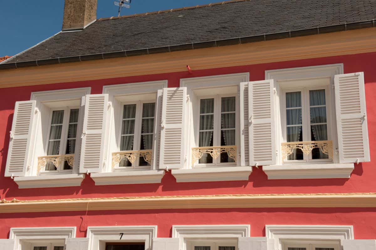 A building with shutters outside the windows