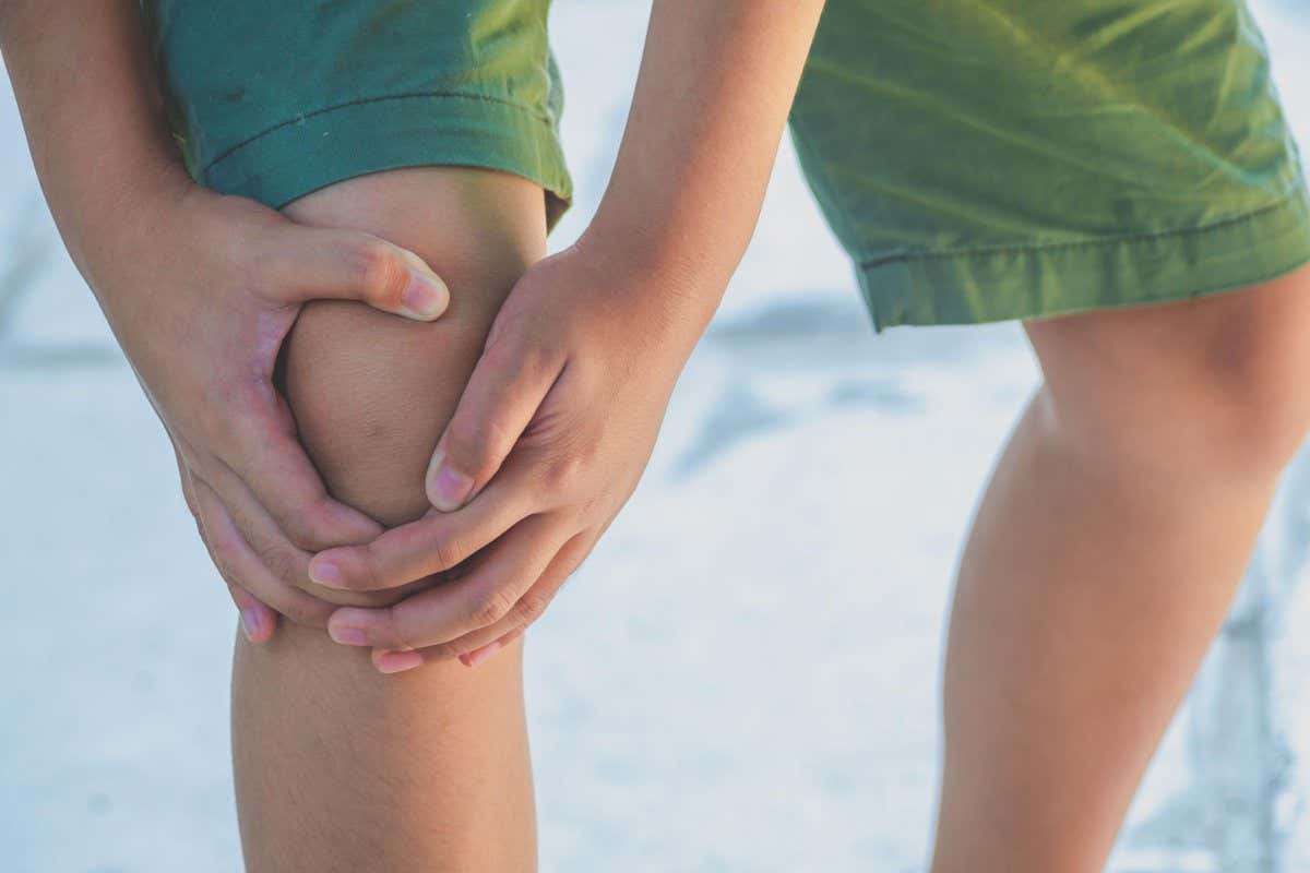 2DKK94C Midsection Of Boy Holding Knee