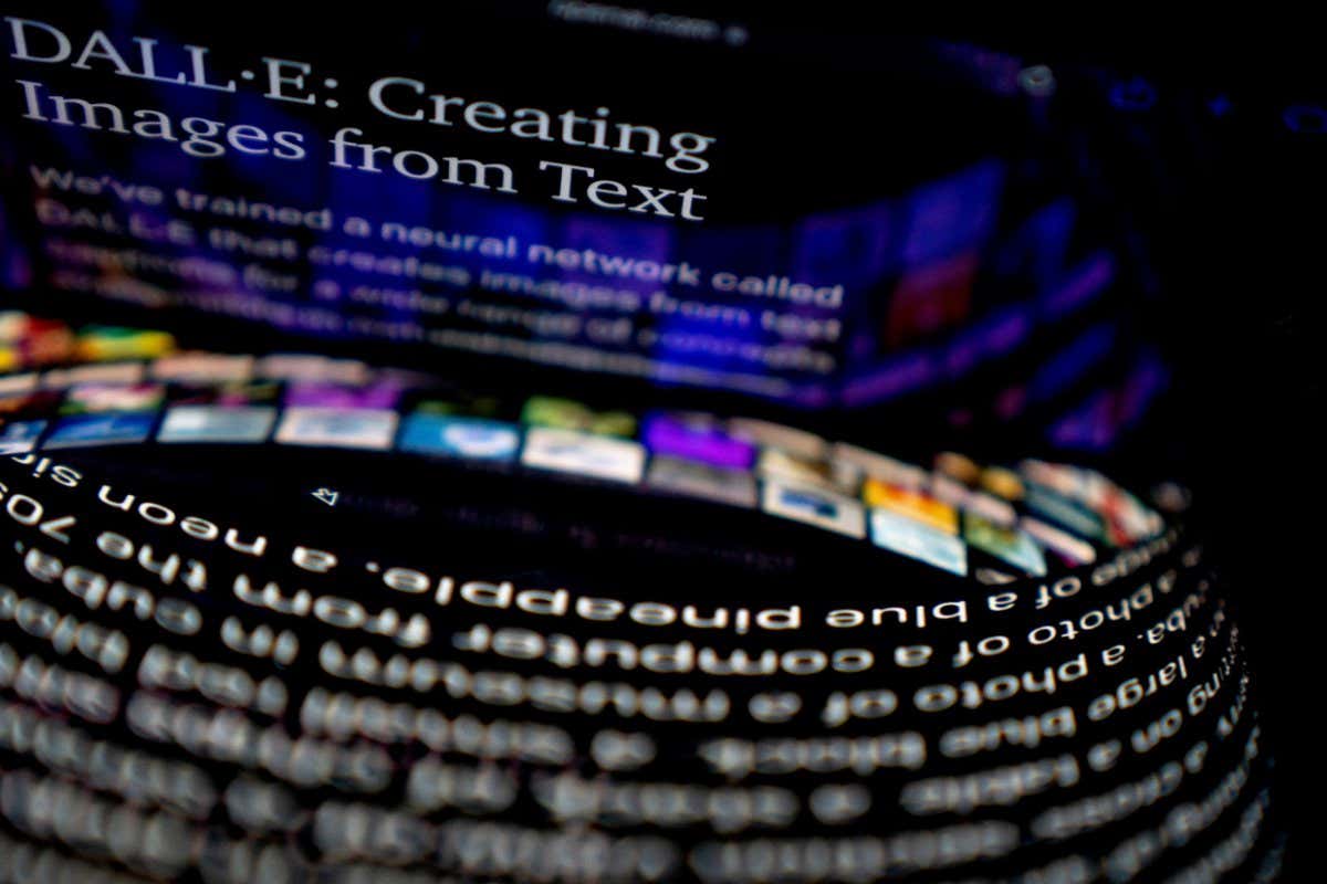 This photo illustration shows the DALL-E website reflected between a computer screen and cellphone in Washington, DC, on July 20, 2022. - A million people eager to dabble with a new artificial intelligence tool that lets them create images simply by describing them with words will soon get their wish, its creators said Wednesday. Artificial intelligence research firm OpenAI is conducting a wide-scale beta test of DALL-E, a cutting-edge software that creates images from textual descriptions. (Photo by Stefani Reynolds / AFP) (Photo by STEFANI REYNOLDS/AFP via Getty Images)