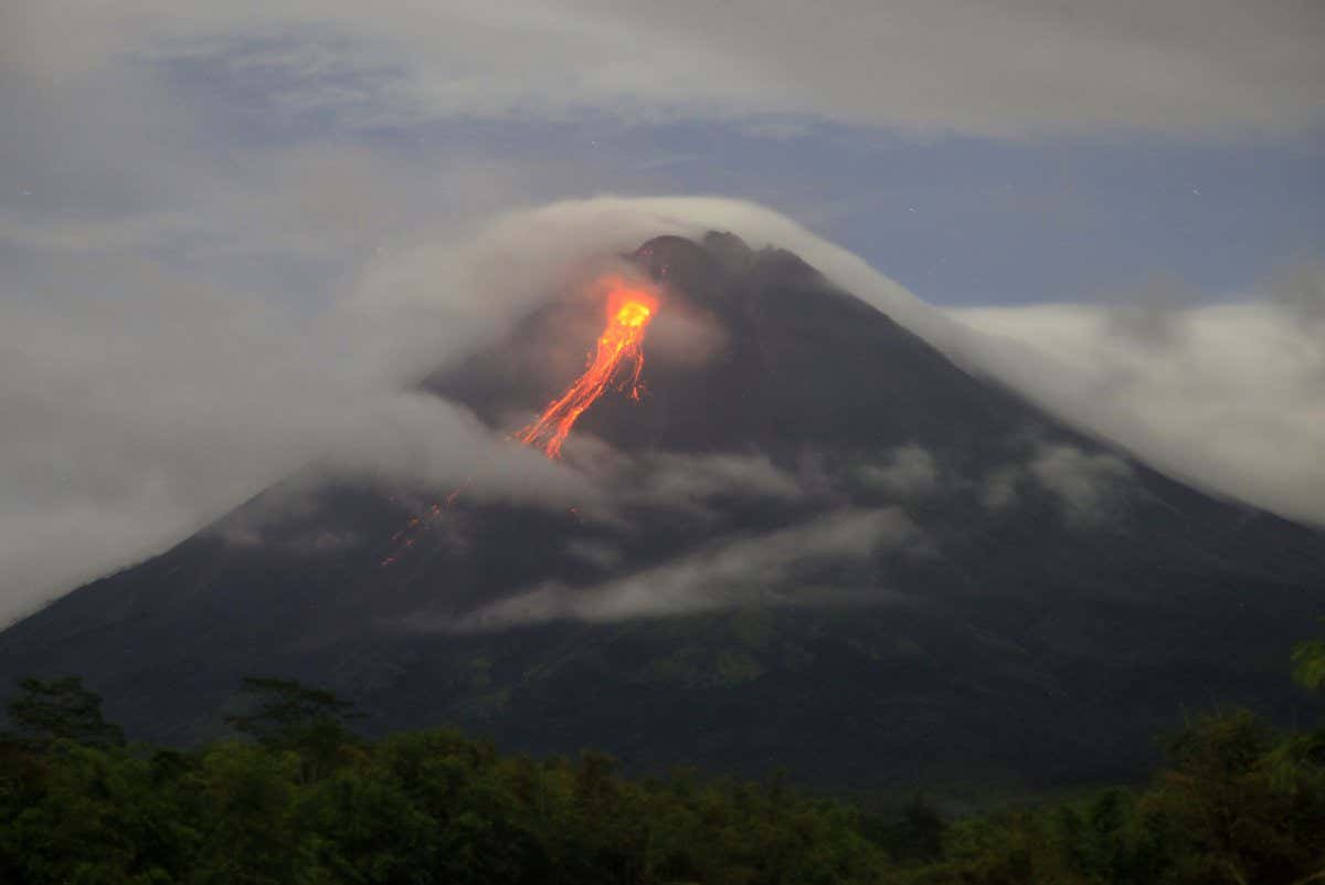 Lava spews from the peak of Merapi volcano during its effusive erruption asw seen from Turgo village, Sleman, Yogyakarta province, on May 19, 2022. (Photo by Aditya Irawan/NurPhoto via Getty Images)
