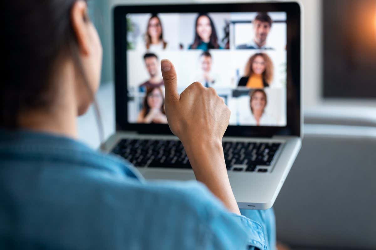 Back view of a woman making video call and showing thumbs up