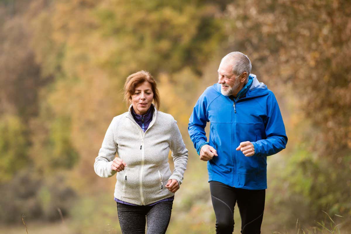 Beautiful senior couple running outside in sunny autumn forest; Shutterstock ID 526175119; purchase_order: -; job: -; client: -; other: -