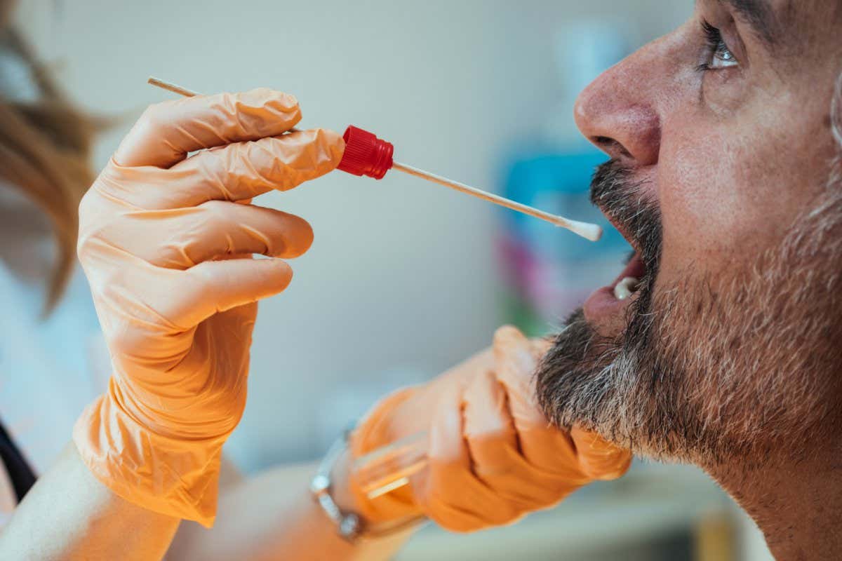 Close Up Photo of Doctor Hands in Orange Gloves Taking Throat Swab Test from Mature Man in the Hospital; Shutterstock ID 2109822863; purchase_order: -; job: -; client: -; other: -