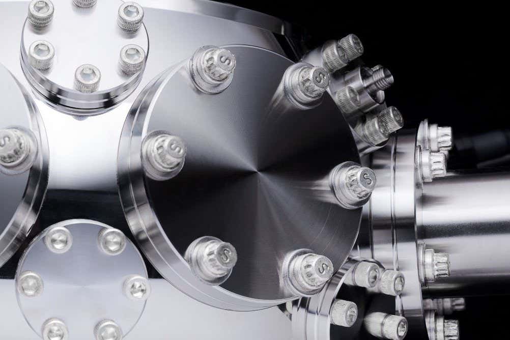 Quantum bits made of charged ytterbium atoms kept in a glass and metal chamber