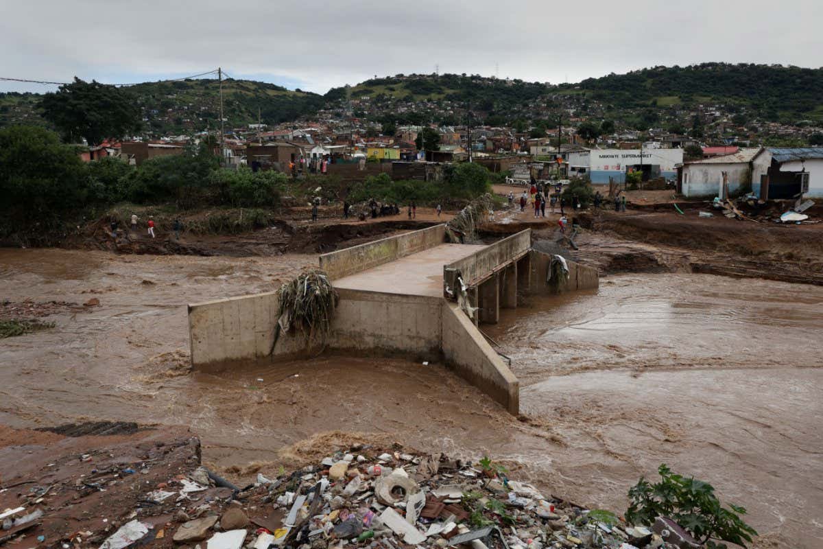 A river runs around a damaged bridge