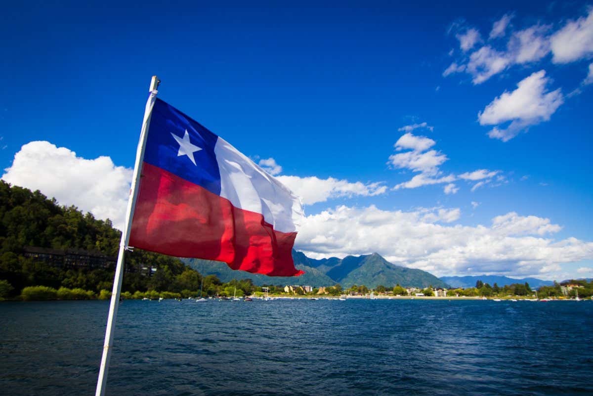 Villarrica lake, Chile in the summer. It is possible to see the lake, the flag of Chile. Sunny day, mountains in the background. Latin America, South America. Volcano, travel.; Shutterstock ID 1967684629; purchase_order: -; job: -; client: -; other: -