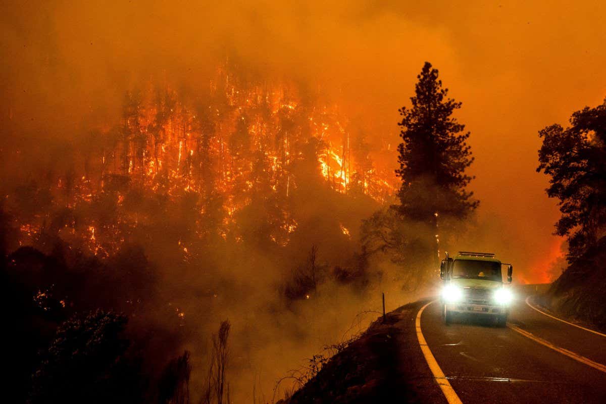 Mandatory Credit: Photo by Noah Berger/AP/Shutterstock (13057572c) Firetruck drives along California Highway 96 as the McKinney Fire burns in Klamath National Forest, Calif Western Wildfires, Klamath National Forest, United States - 30 Jul 2022