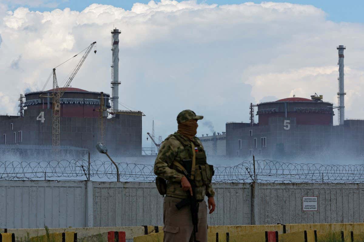 A serviceman with a Russian flag on his uniform stands guard near the Zaporizhzhia Nuclear Power Plant in the course of Ukraine-Russia conflict outside the Russian-controlled city of Enerhodar in the Zaporizhzhia region, Ukraine August 4, 2022. REUTERS/Alexander Ermochenko - RC2LPV9MUYER