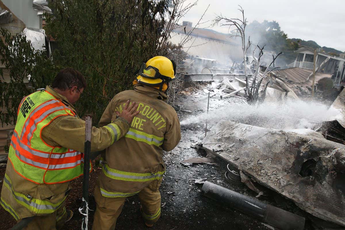 Firefighters spray foam on a fire after an earthquake in Napa, California, in 2014