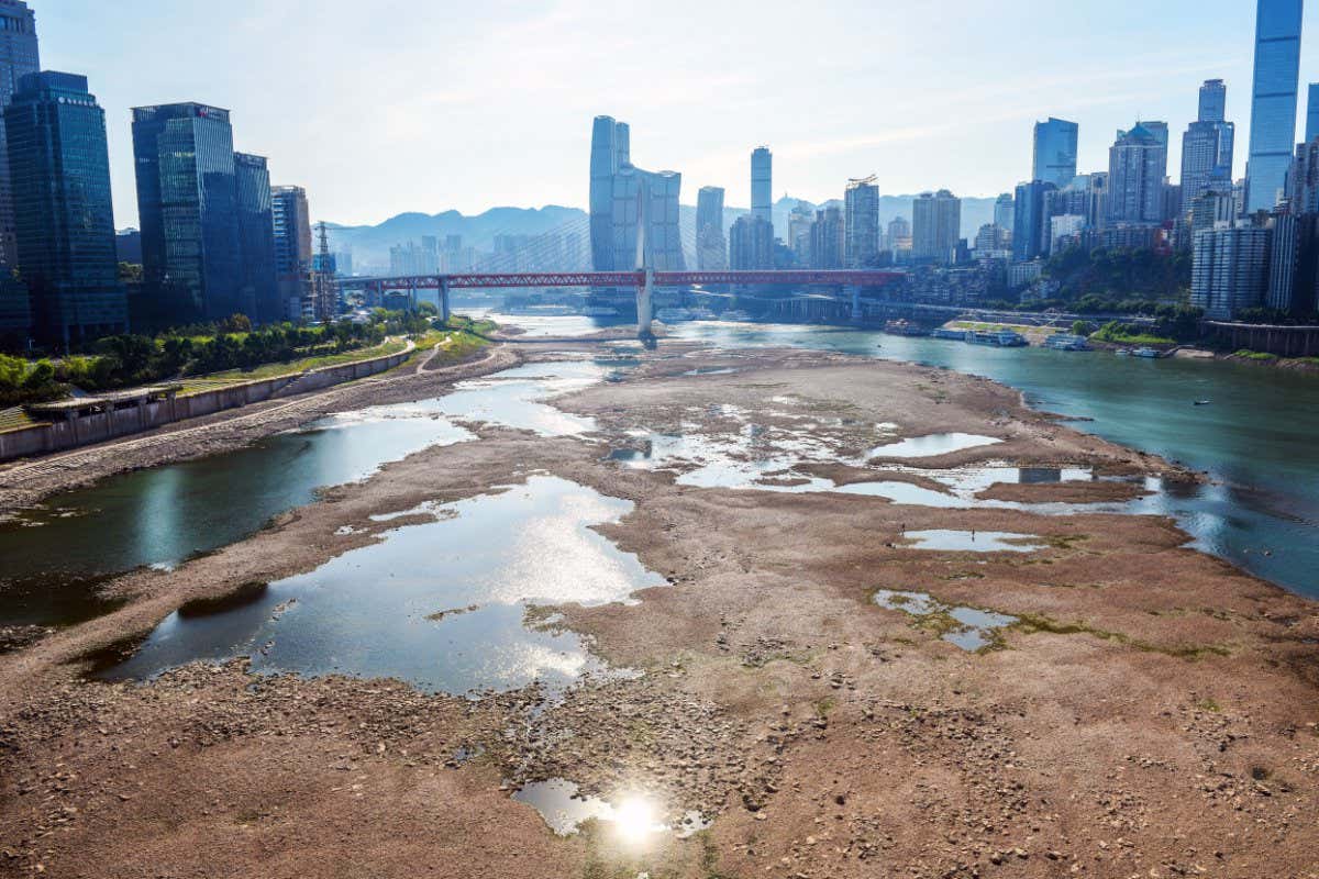 Exposed river bed with city skyline in the background
