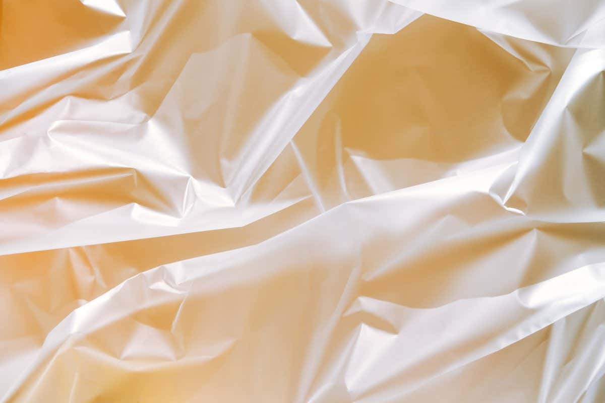 Crumpled beige polyethylene. Folds create abstract pattern with shadows and lights