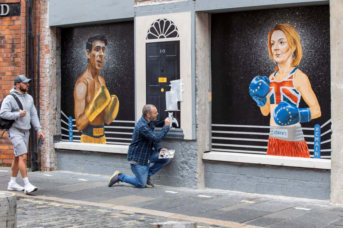 Artist Ciaran Gallagher painting a mural in Belfast depicting the candidates vying to be the next UK prime minister