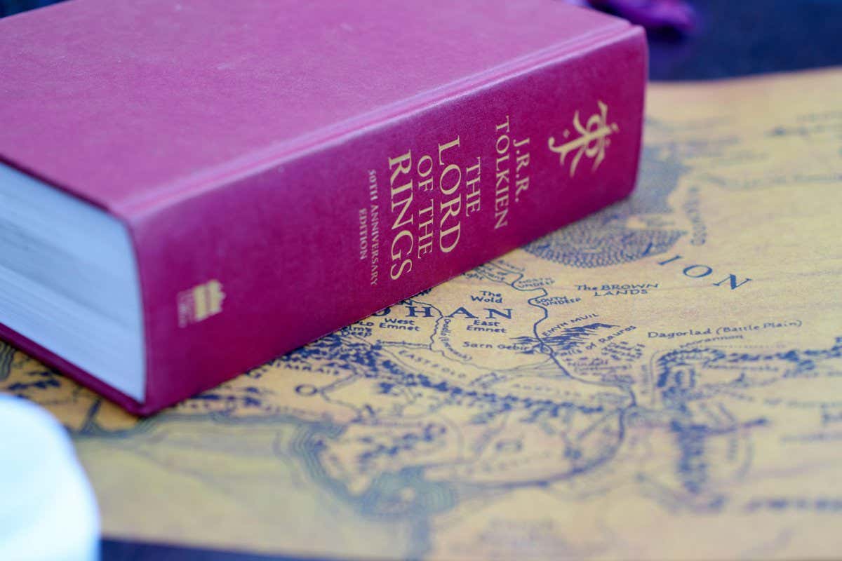 2FMXHTK Red thick Lord of the Rings book lies on Middle-Earth map