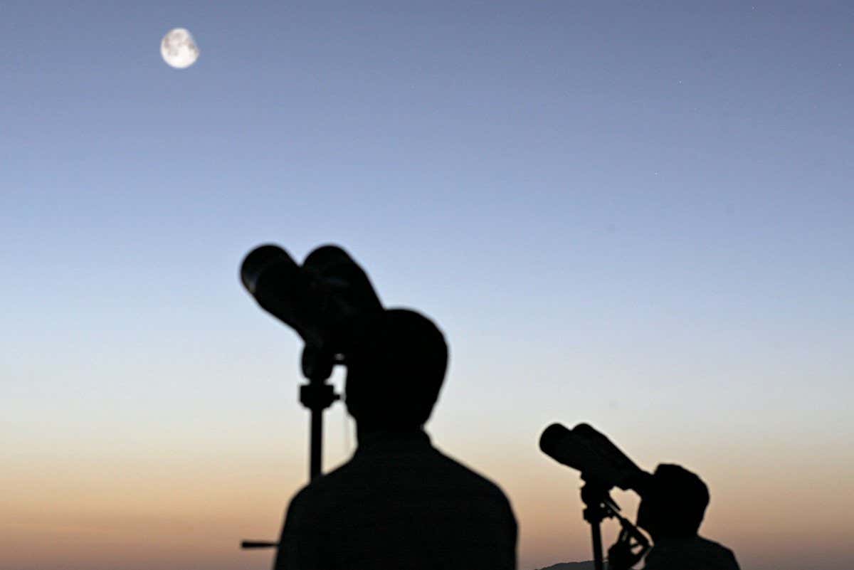 Observing the crescent Moon by binoculars.