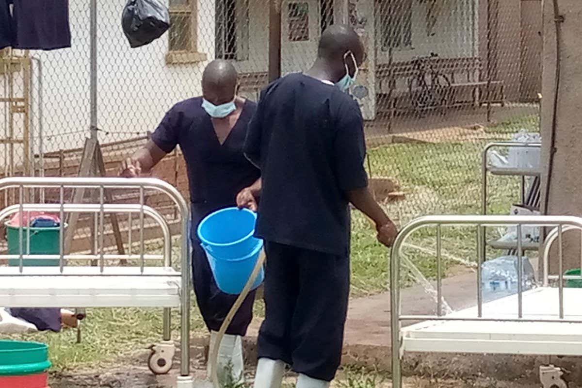 Medical workers disinfect beds at an Ebola treatment centre in Mubende, Uganda