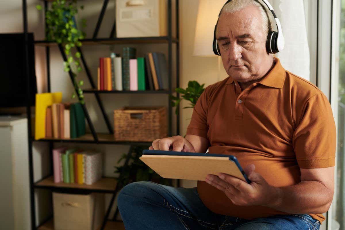 A man listening to music via application on tablet computer