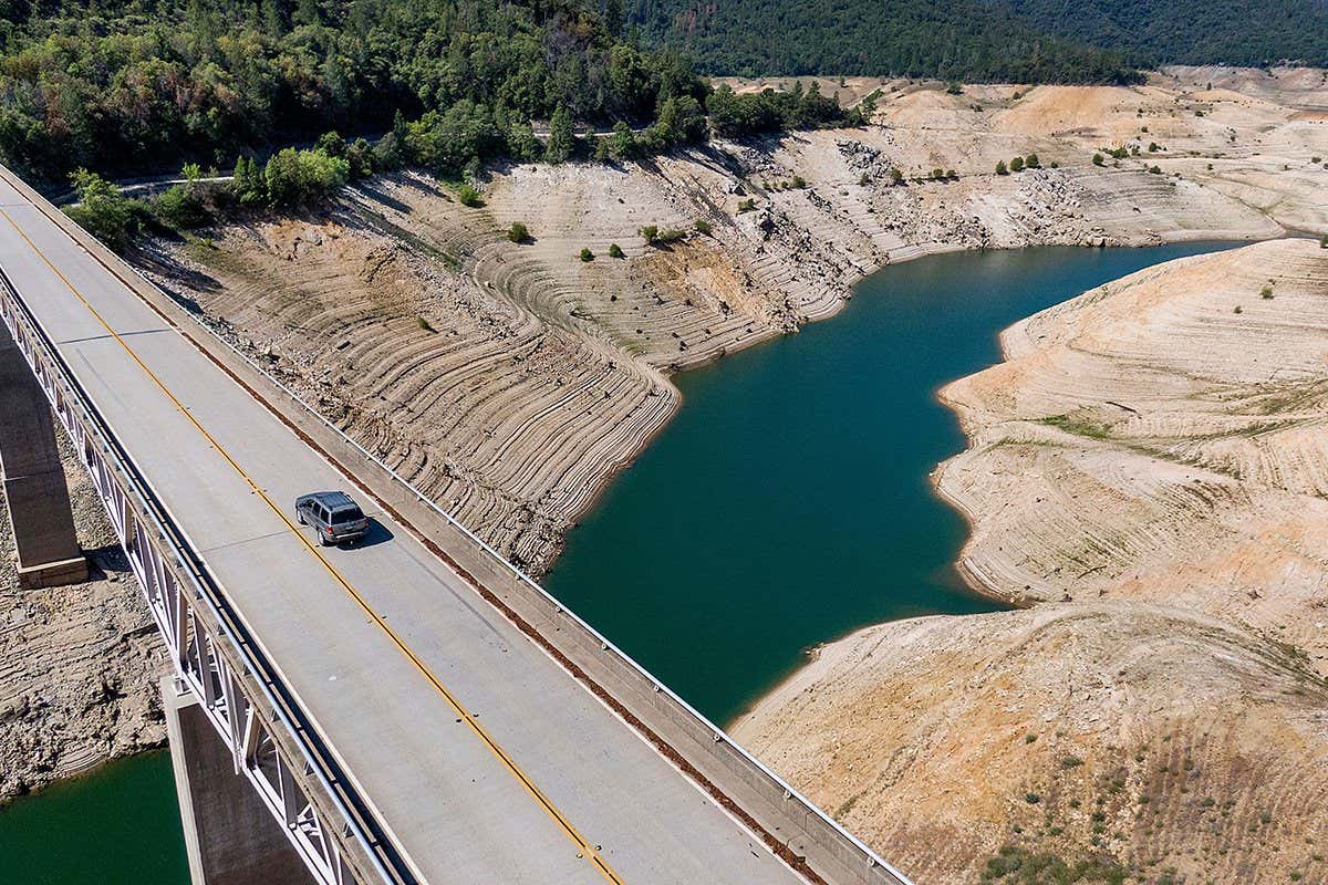 A car crosses Enterprise Bridge over Lake Oroville's dry banks, in Oroville, Calif.