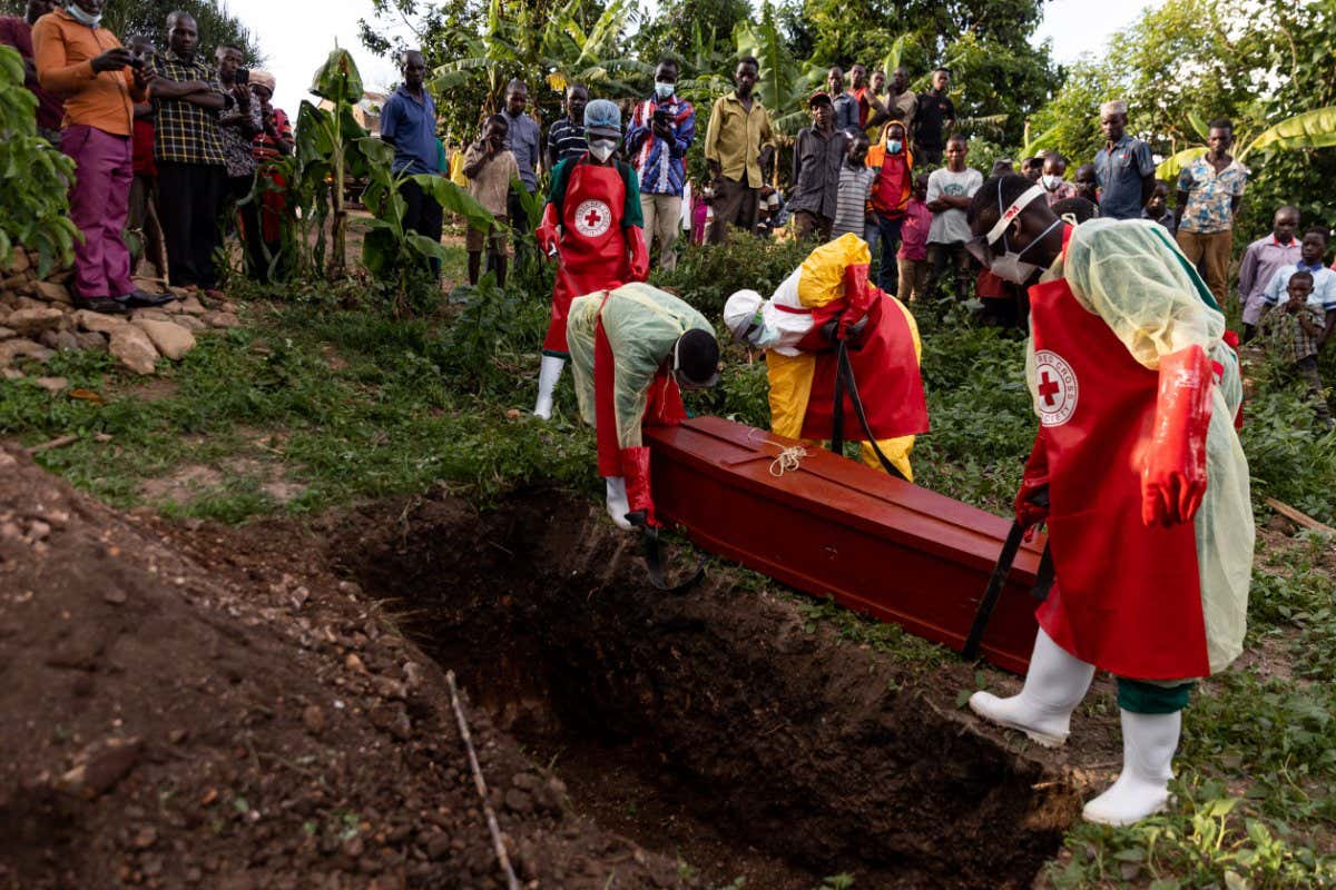Red Cross workers place a coffin, containing someone who died of Ebola, into a grave on October 11 in Mubende, Uganda