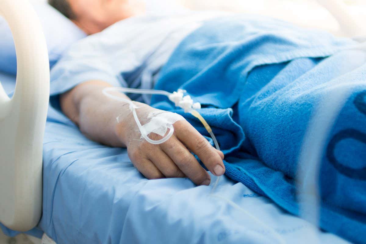 Focus on the hand of a patient in hospital ward;