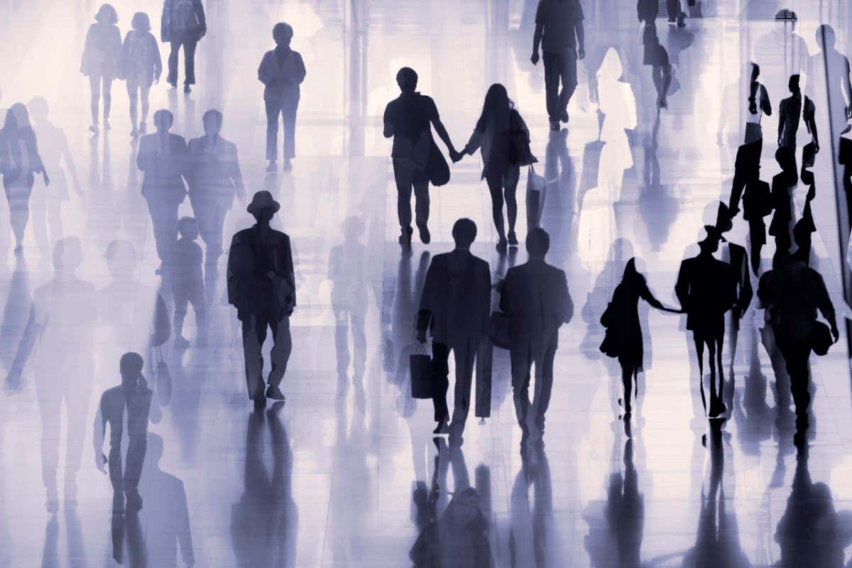 Large group of people on the move, some shopping, some holding hands, others just walking along.