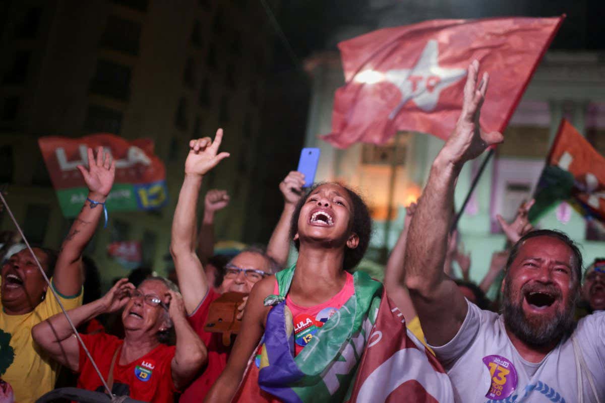 Crowd of people cheering with flags and banners