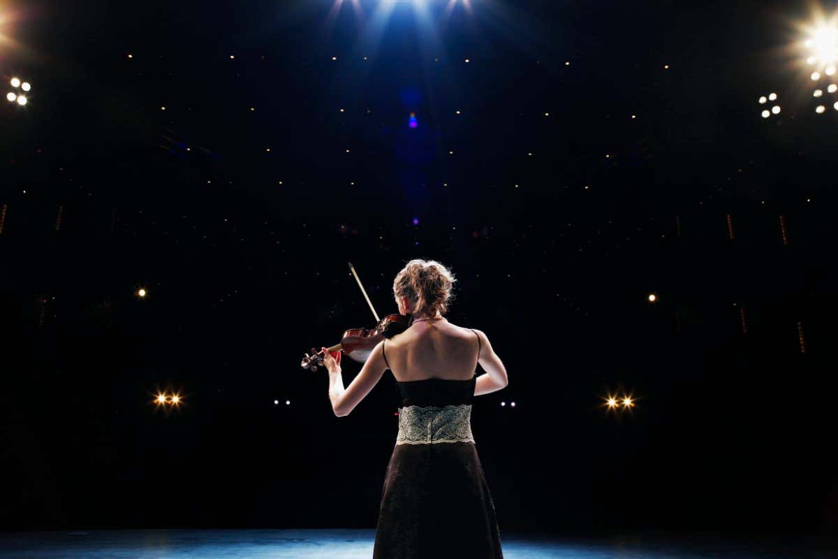 Young woman playing violin solo on stage